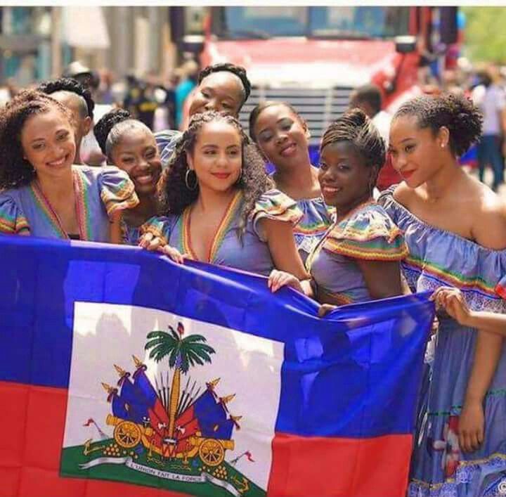 Haitian women in traditional dresses holding the national flag during a cultural celebration