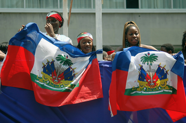 The Haitian youths proudly holding Haitian flags during a cultural celebration.