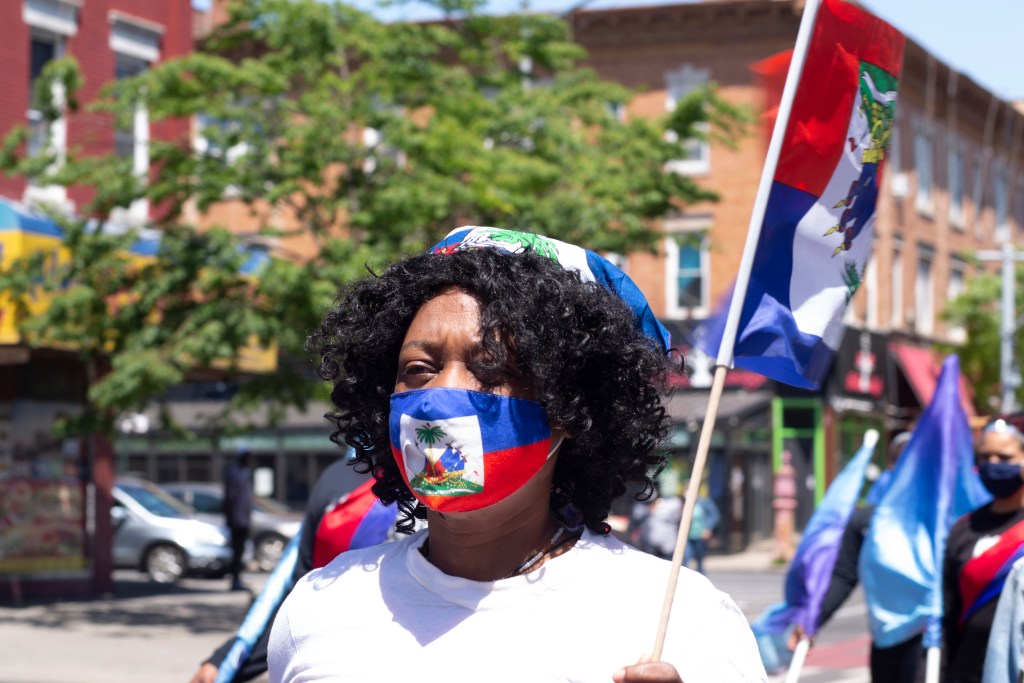 A Haitian woman in her full fit representing the Haitian community during a acelebartion