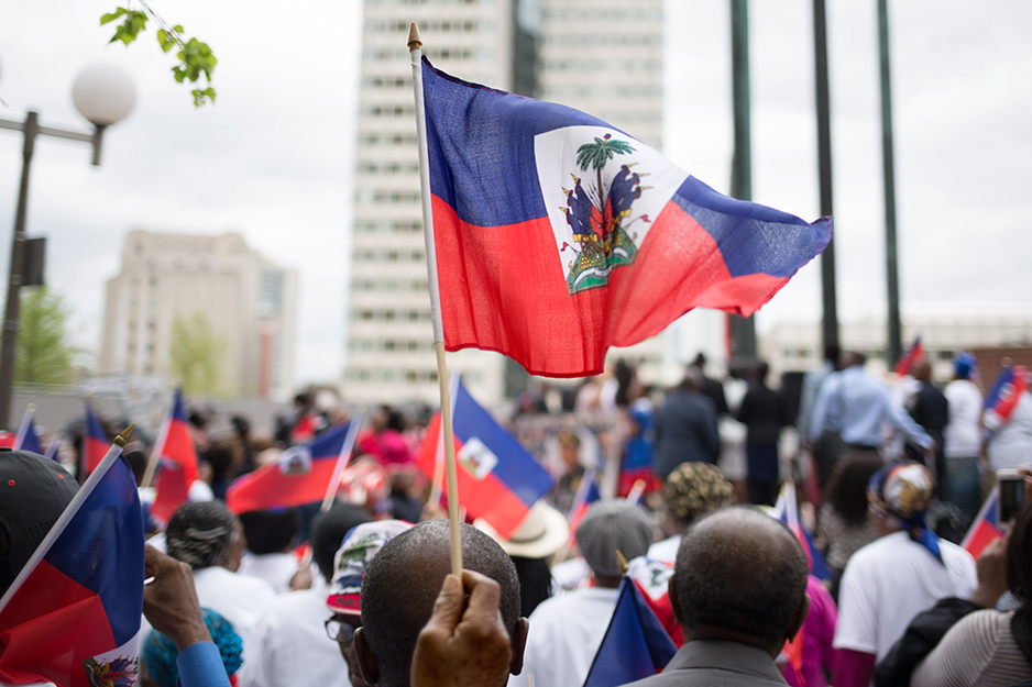 A crowd of people waving Haitian flags at a heritage celebration in Boston, USA.