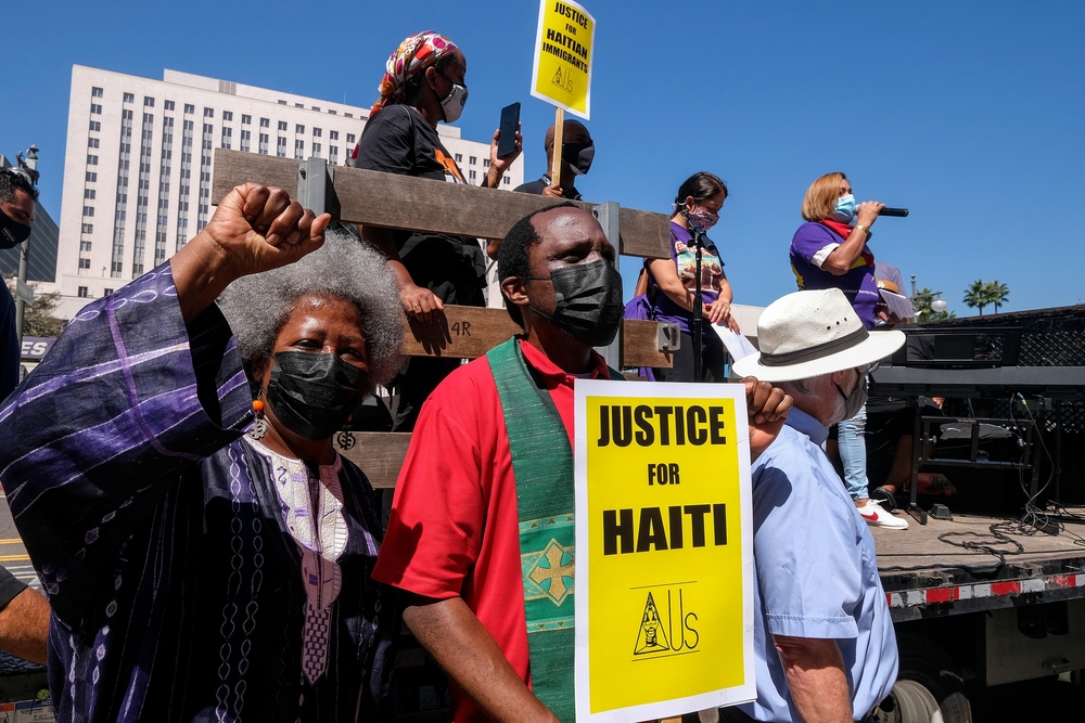 Protesters holding “Justice for Haiti” signs at a rally for Haitian immigrants